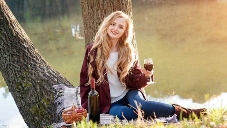 Woman drinking in wine at park.