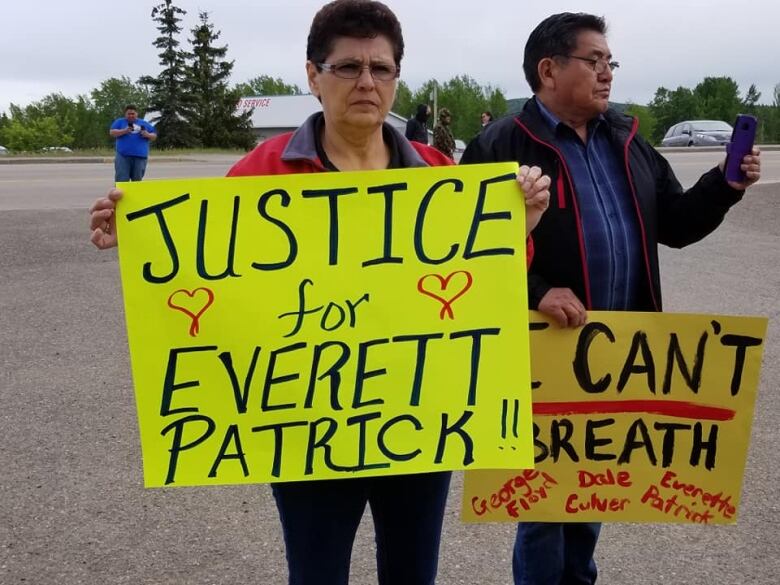 A woman holds up a sign that reads 'Justice for Everett Patrick.'