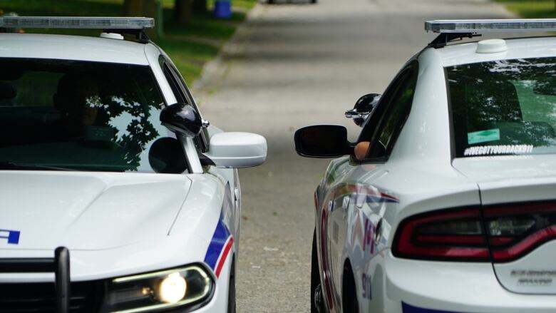 two cop cars parked together to officers can talk