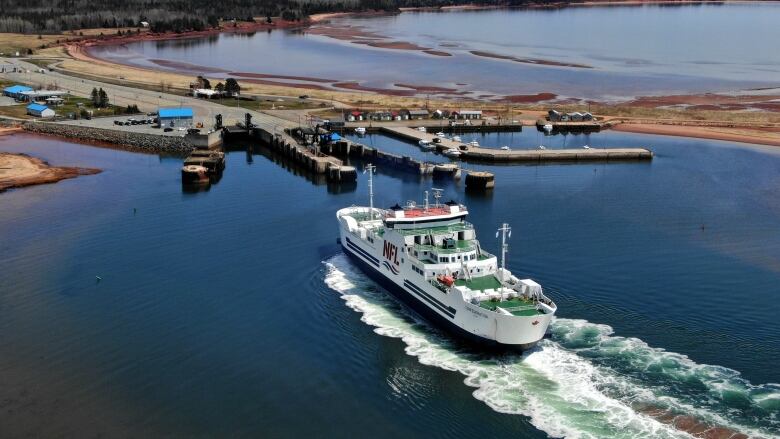 A large passenger and vehicle ferry is shown approaching the shore of Prince Edward Island. 