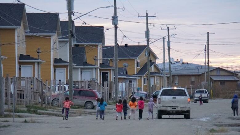 Kids on a street lined with houses