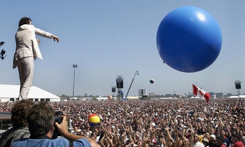 Performer on stage sending huge balloon over crowd