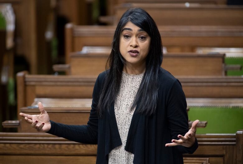 A woman in a black shawl speaks in the House of Commons.