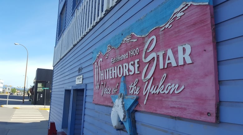 A sign on the side of a building reads, 'The Whitehorse Star.'