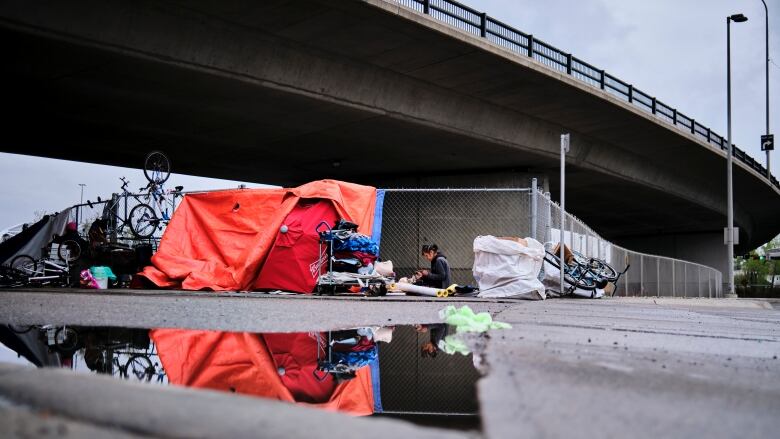 A tent is set up under a bridge in the inner city.