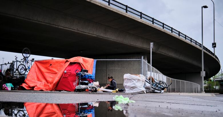 A tent is set up under a bridge in the inner city.