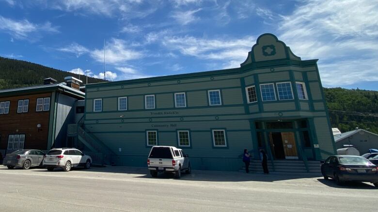 A building sits on a quiet street beneath a striking blue sky.