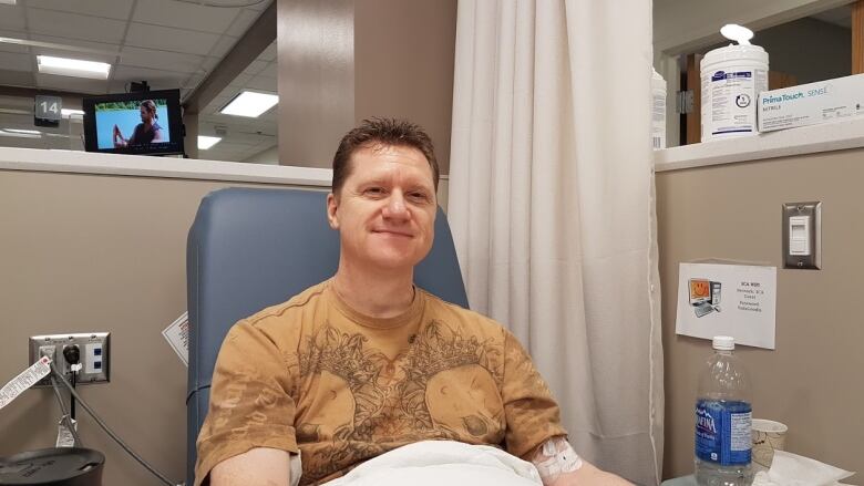 A man reclines in a medical chair.