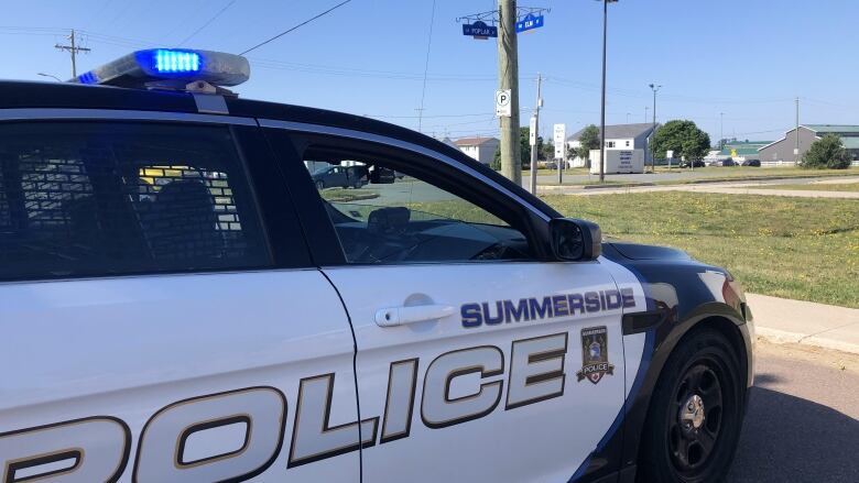 Summerside police cruiser parked near grassy area.