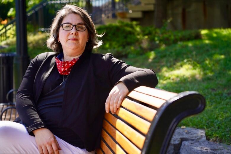 Woman sits on a bench.