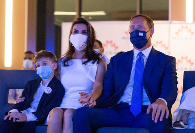 Peter MacKay shown sitting masked with his wife, Nazanin Afshin-Jam MacKay and son Kian