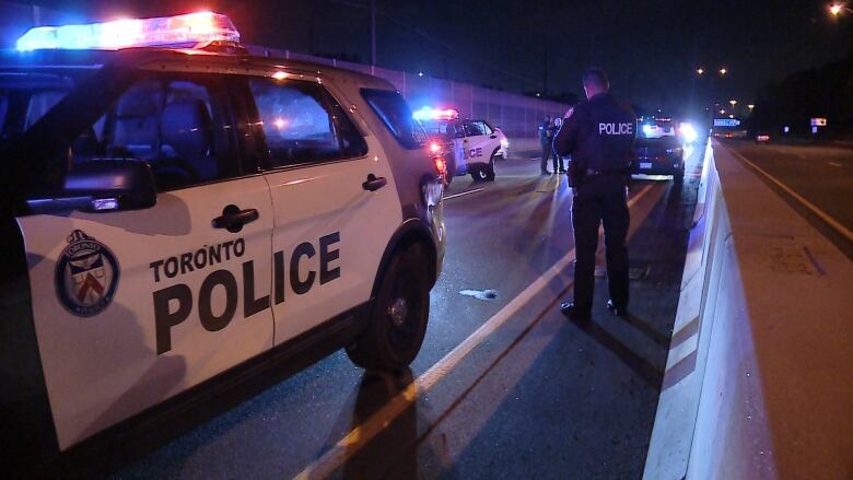 Police cars on a highway at night.