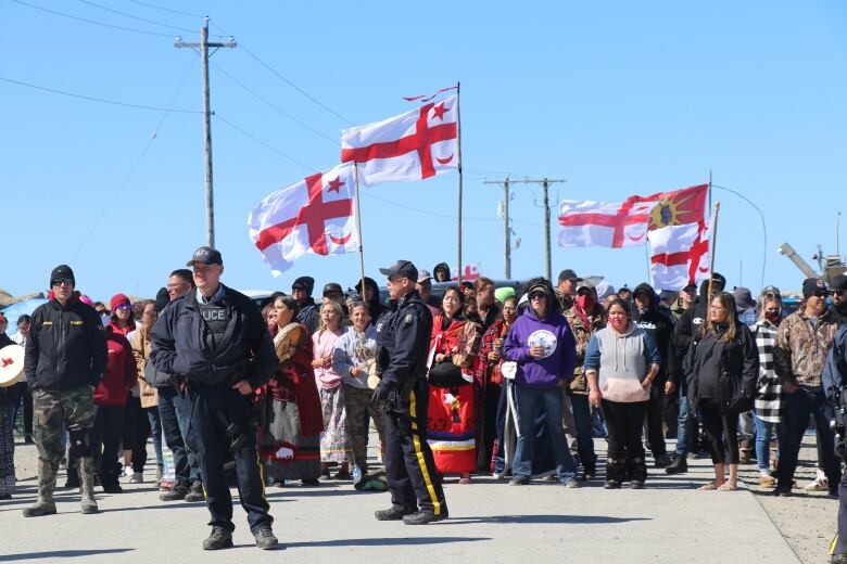 people holding flags near shore