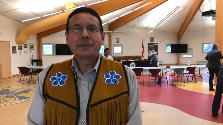 A portrait of a man in a beaded vest.