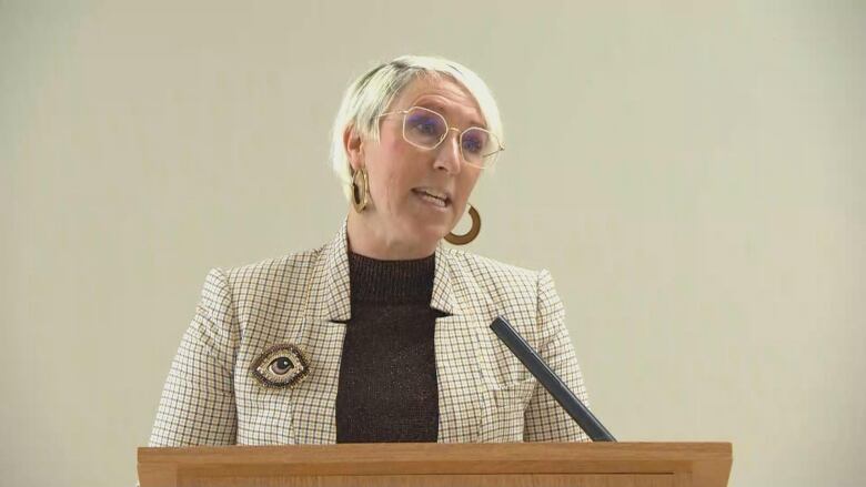 A woman speaks at a podium.