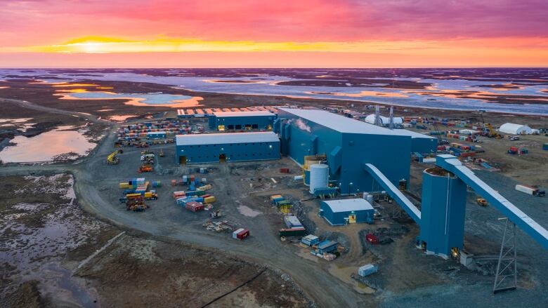 Buildings on tundra, red sky.