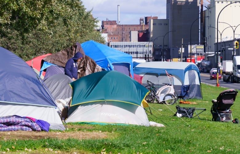 several tents are set up next to a roadway in an industrial area