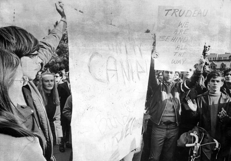 Demonstrators hold up signs calling for unity