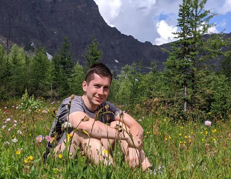 Young man sitting in a field.