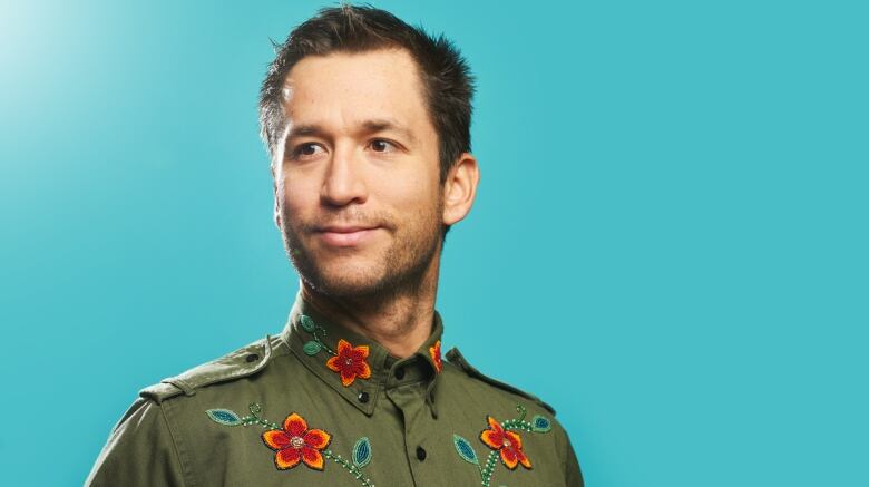 A man wearing a shirt with beaded flowers is pictured.