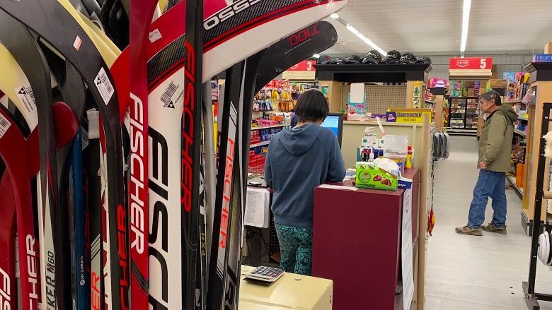 Hockey sticks, cashier, grocery shelves.