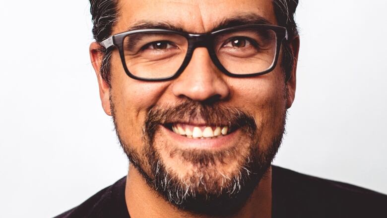 An Indigenous man smiles into the camera.