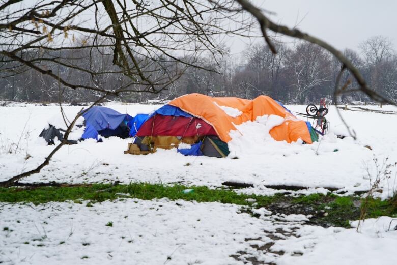 a bunch of tents at a homeless encampment covered in snow