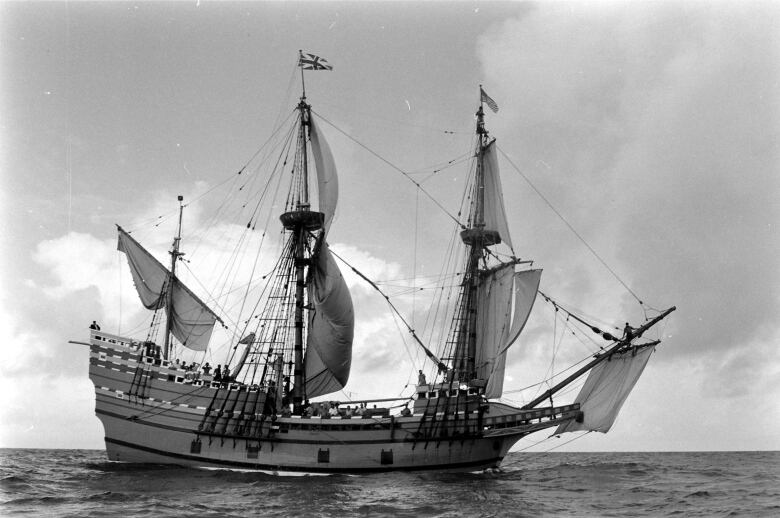 A black and white picture of a tall ship.