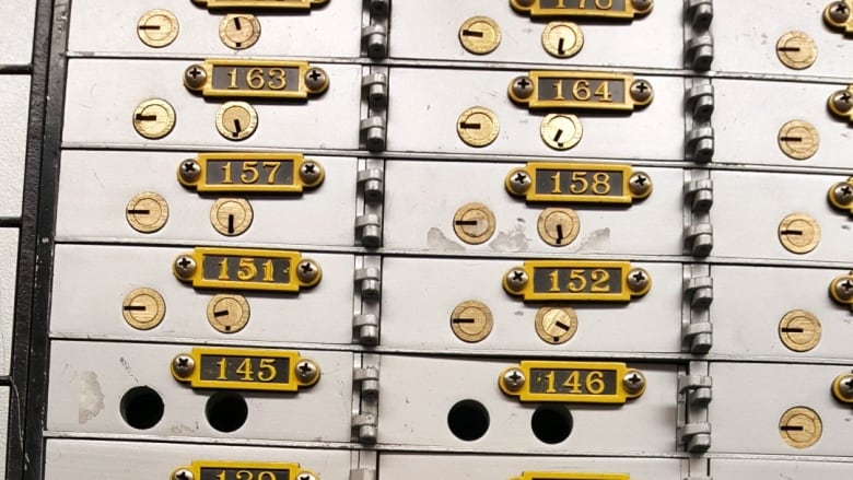 Safety deposit boxes, two seen with drill holes.