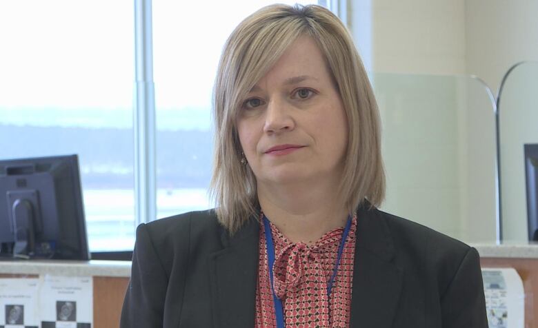 Woman with short blonde hair and blazer.