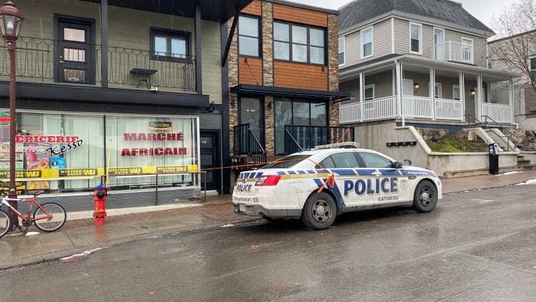 A police car parked on a street in front of several houses.