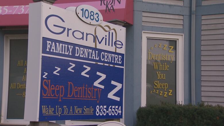 A sign for a dentist's office is shown.