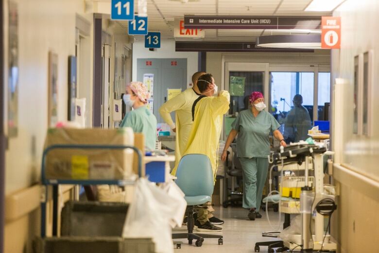 Nurses inside a hospital hallway.