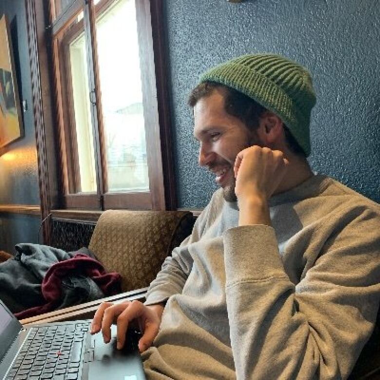 A man sits at a computer keyboard.