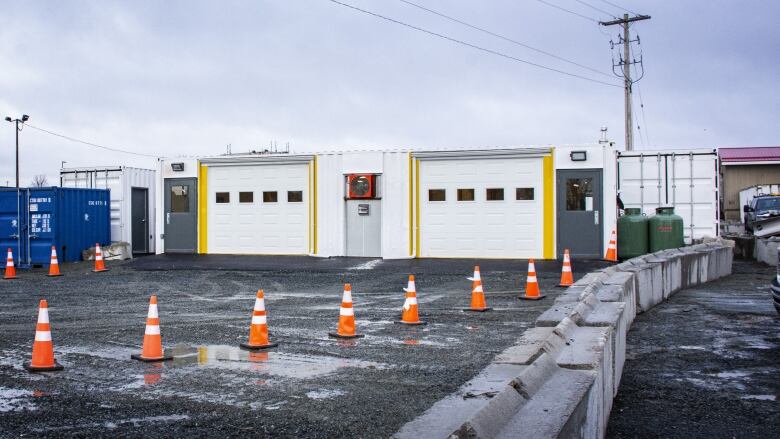 The outside view of a drive-thru at Dartmouth General Hospital, showing two white bay doors, where people can now get a COVID-19 vaccine and flu shot, COVID testing, and blood collection. 