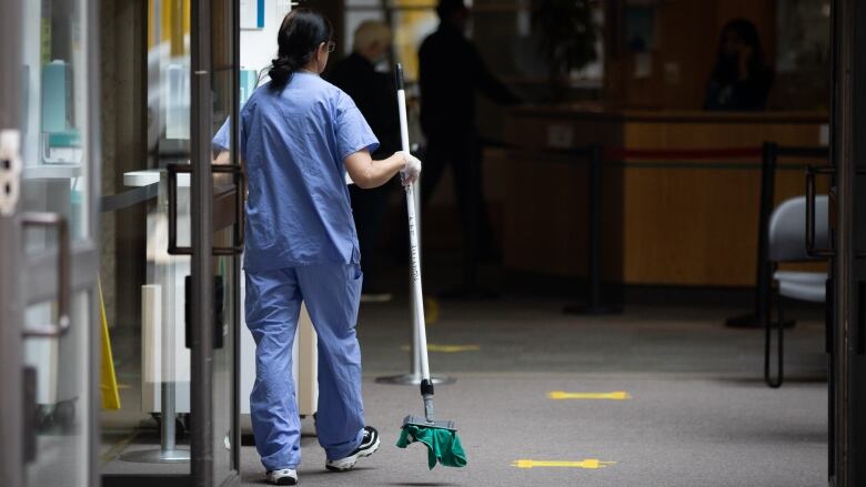 A person in scrubs inside a hospital corridor