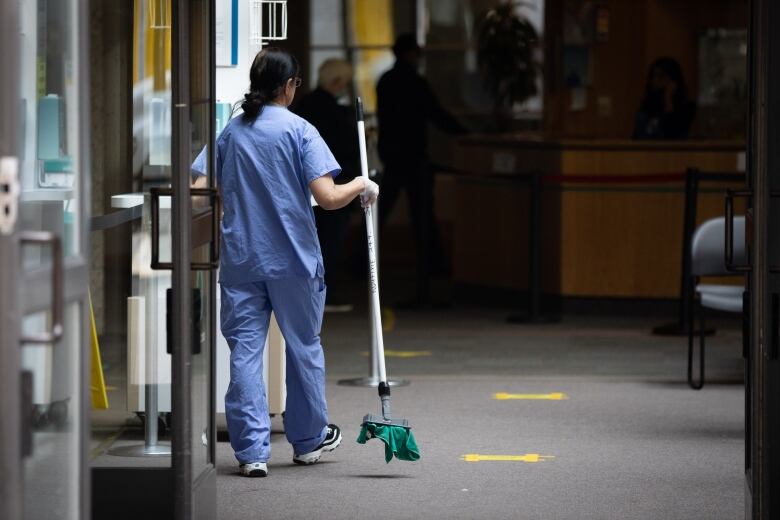 A person in scrubs inside a hospital corridor