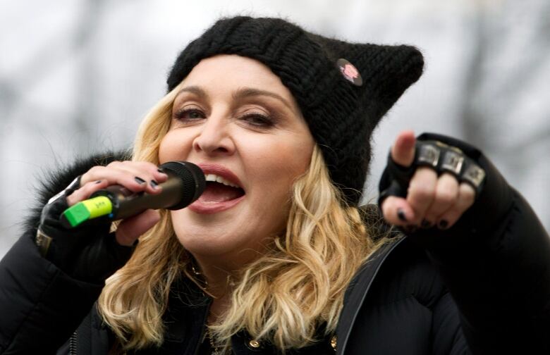 A woman sings into a microphone.