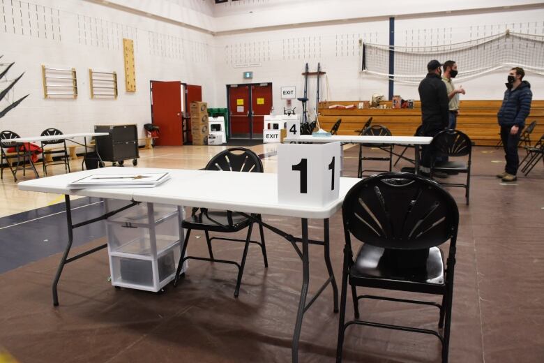 A vaccine clinic is set up in a school gymnasium.