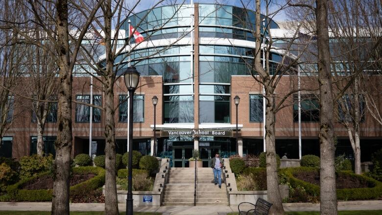 A three-storey glass and red brick building with a curved glass entrance.