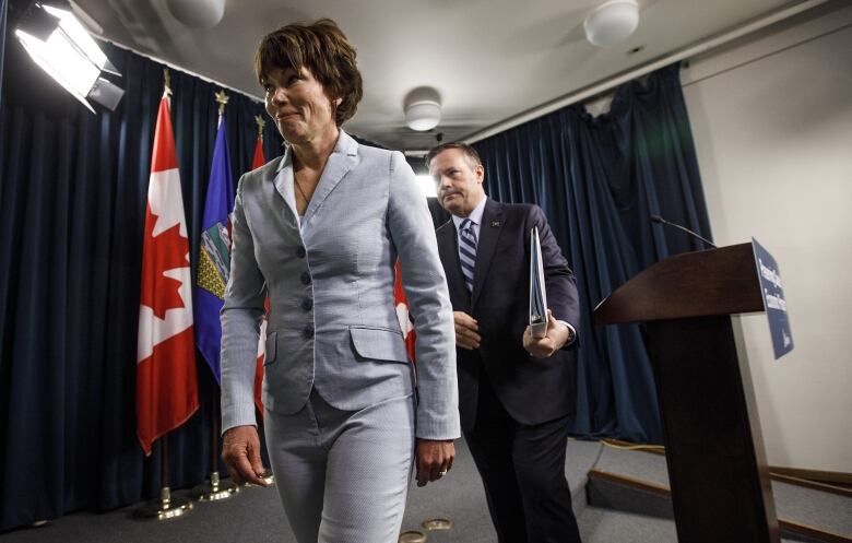 Alberta Energy Minister Sonya Savage walks out of a news conference in 2021, with then-premier Jason Kenney behind her. 