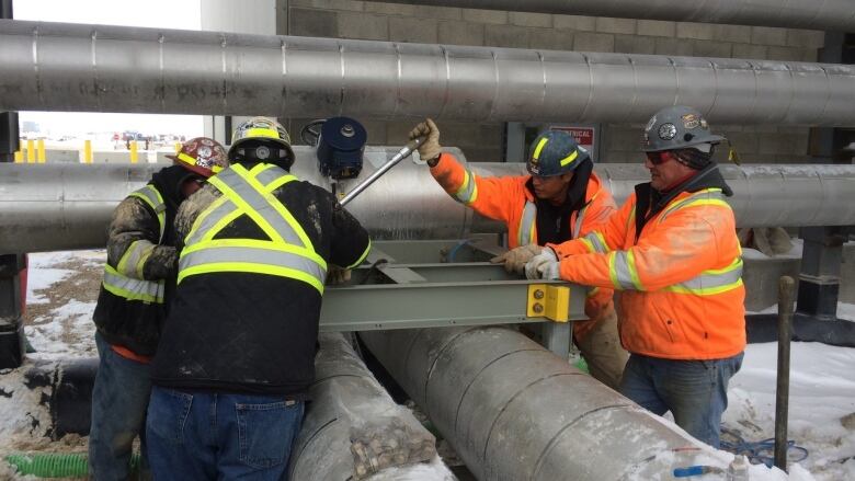 Construction workers working on pipes. 