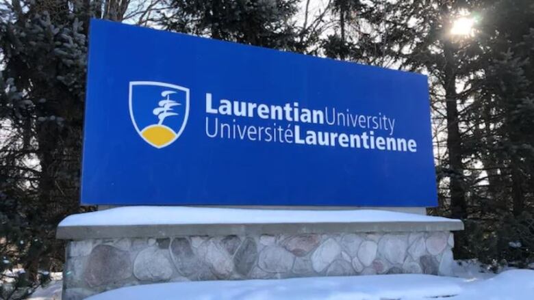 Blue Laurentian sign in the winter, surrounded by snow. 