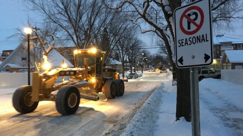 A snow and ice grader clears an Edmonton snowy street.