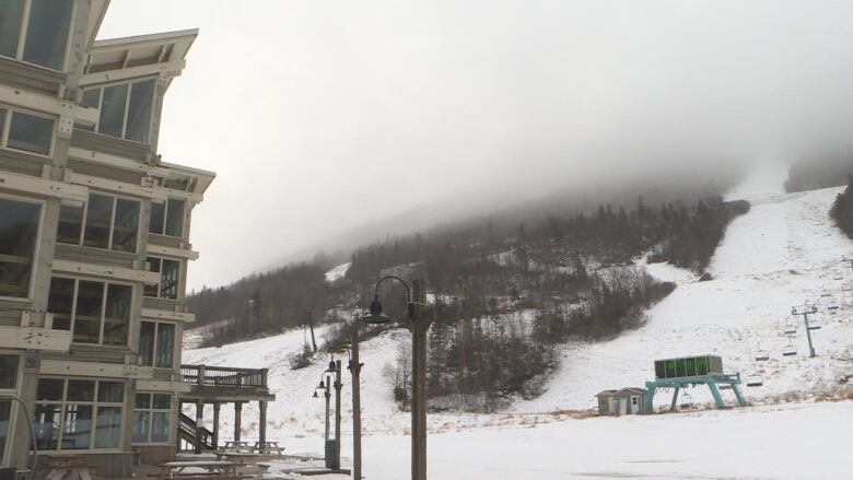 A large ski lodge facing a ski hill. 