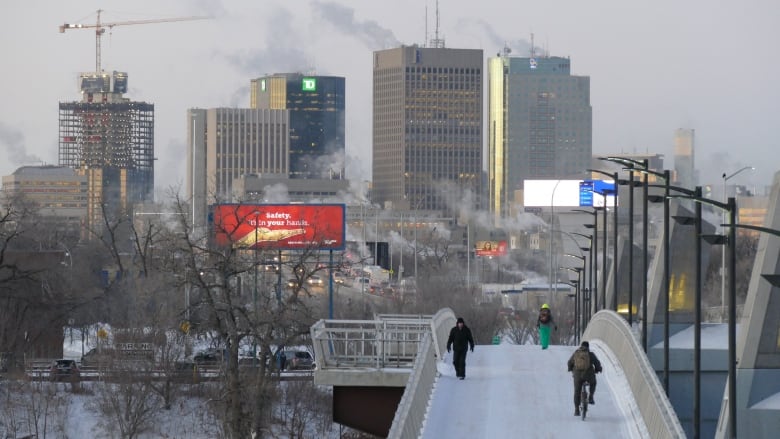 View of buildings in downtown Winnipeg with pedestrian bridge in the foreground.