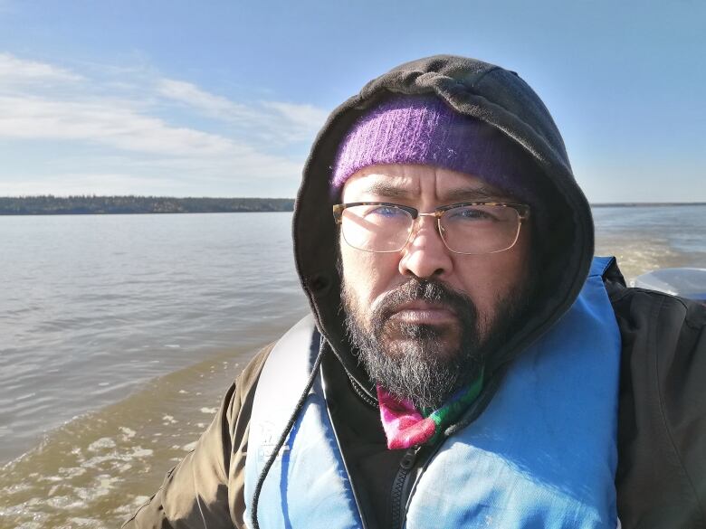 A portrait of a man by a lake.