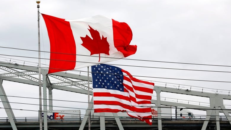 Canadian and U.S. flags fly at a border crossing.