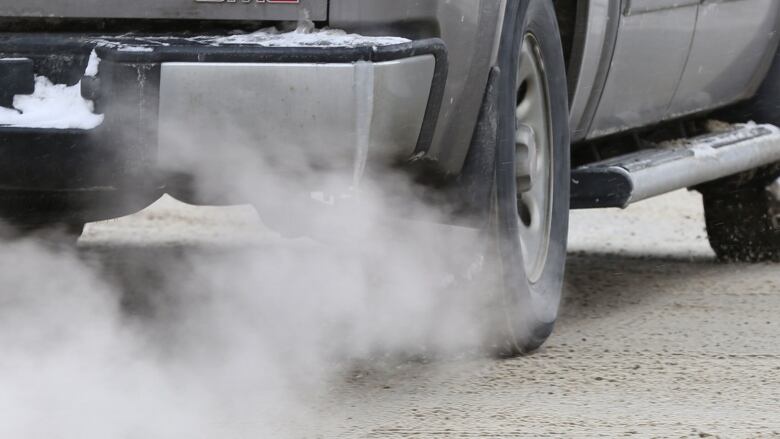 Vapour and smoke flow out of the exhaust pipe of a truck.