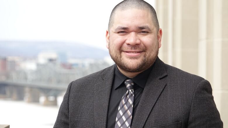 A man wearing a suit smiles.